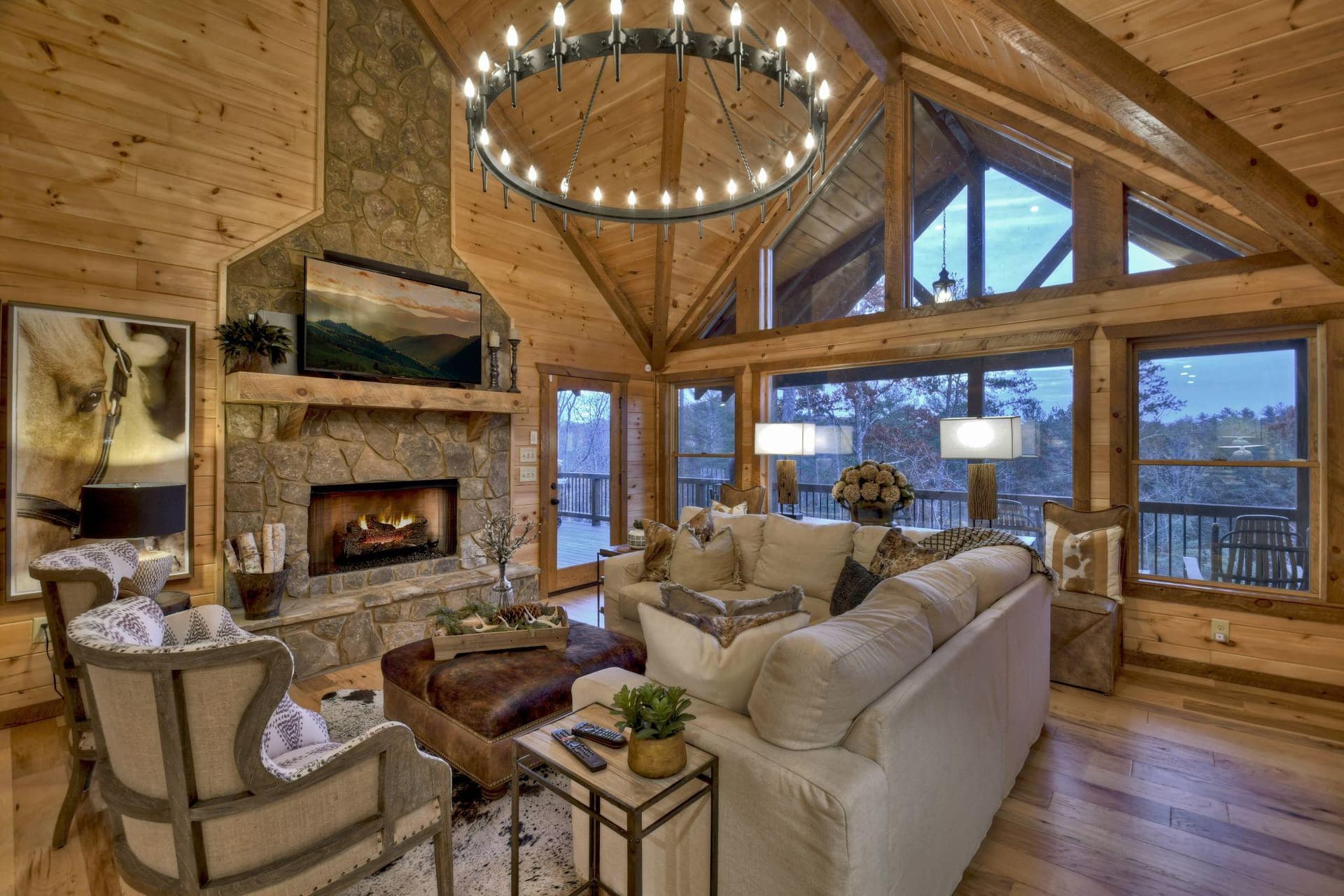Cabin living area with a stone fireplace, vaulted timber ceiling and a light sectional